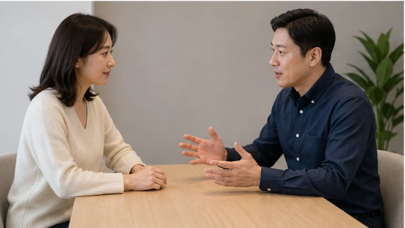 상담실 나무 테이블에서 두 사람이 마주 앉아 일정에 관해 이야기하는 모습