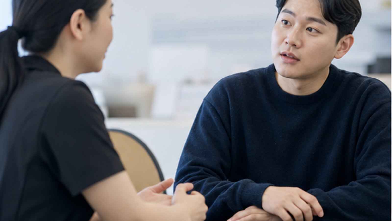 상담 데스크에서 문의 내용을 이야기하는 내원자 — 스마일라식 비용 문의 확인 경로 안내