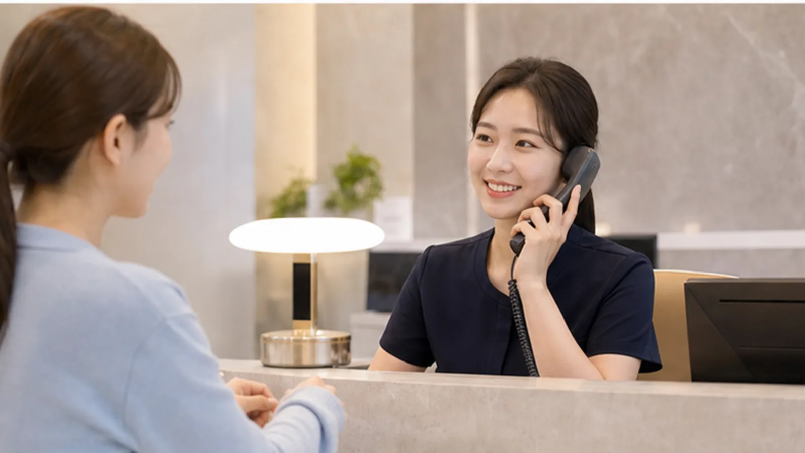 안과 접수 데스크에서 전화 문의와 방문 일정을 확인하는 모습