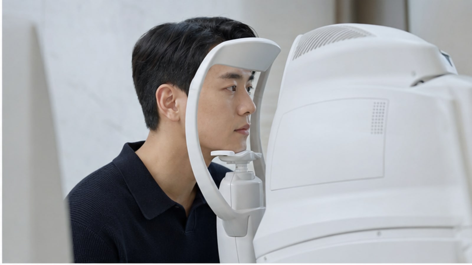 안과 검사 장비로 눈 상태를 확인받는 내원자