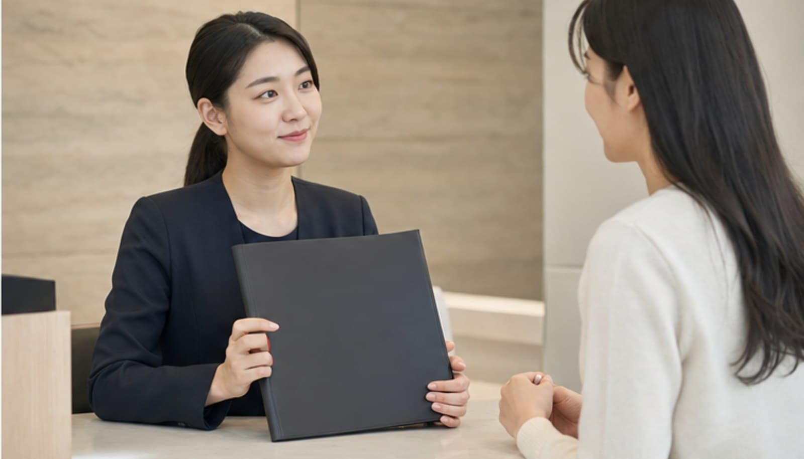 안과 접수 데스크에서 직원이 내원자에게 안내 자료를 건네며 응대하는 모습