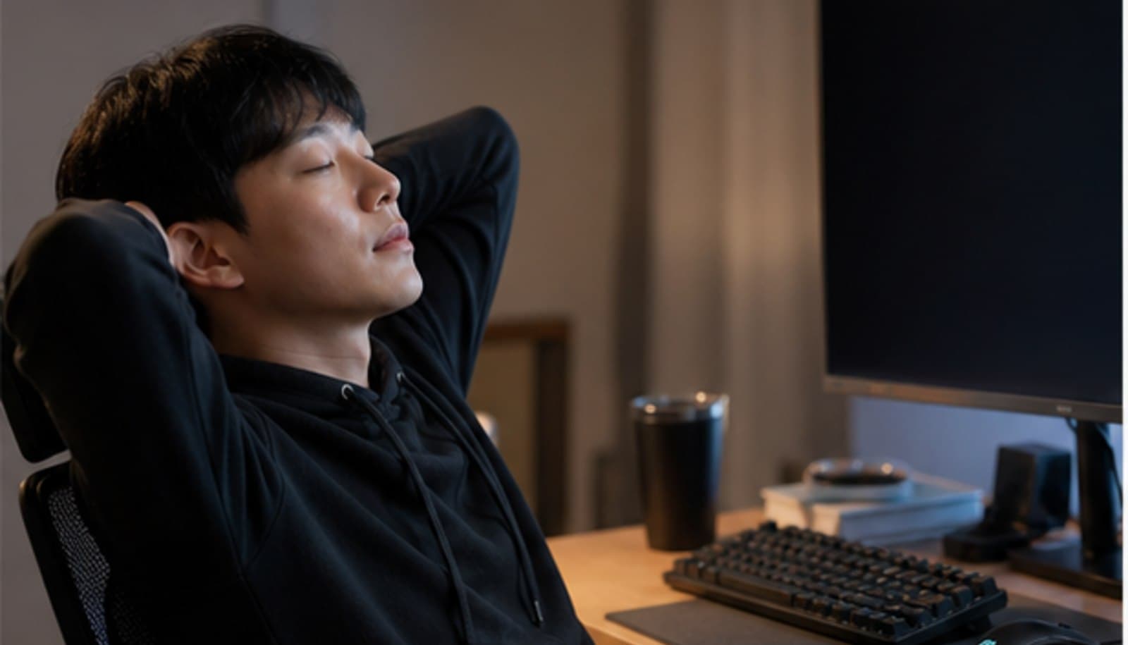 어두운 방 책상 앞에서 모니터를 끄고 의자에 기대어 눈을 감고 쉬는 모습 — 스마일라식 후 게임과 화면 사용 상담 안내
